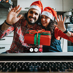 Two people celebrating the holidays shown on a computer screen