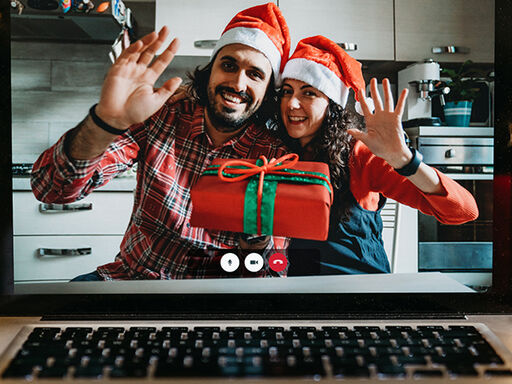 Two people celebrating the holidays shown on a computer screen