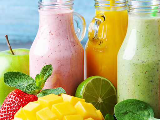 Image of 5 jars of smoothies surrounded by colorful fruit