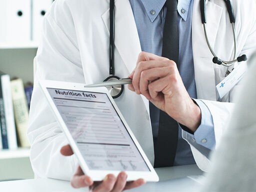Image of a doctor showing nutritional facts on an iPad to a patient